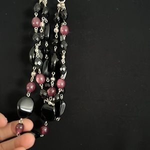 woman’s three strand silver black and purple necklace